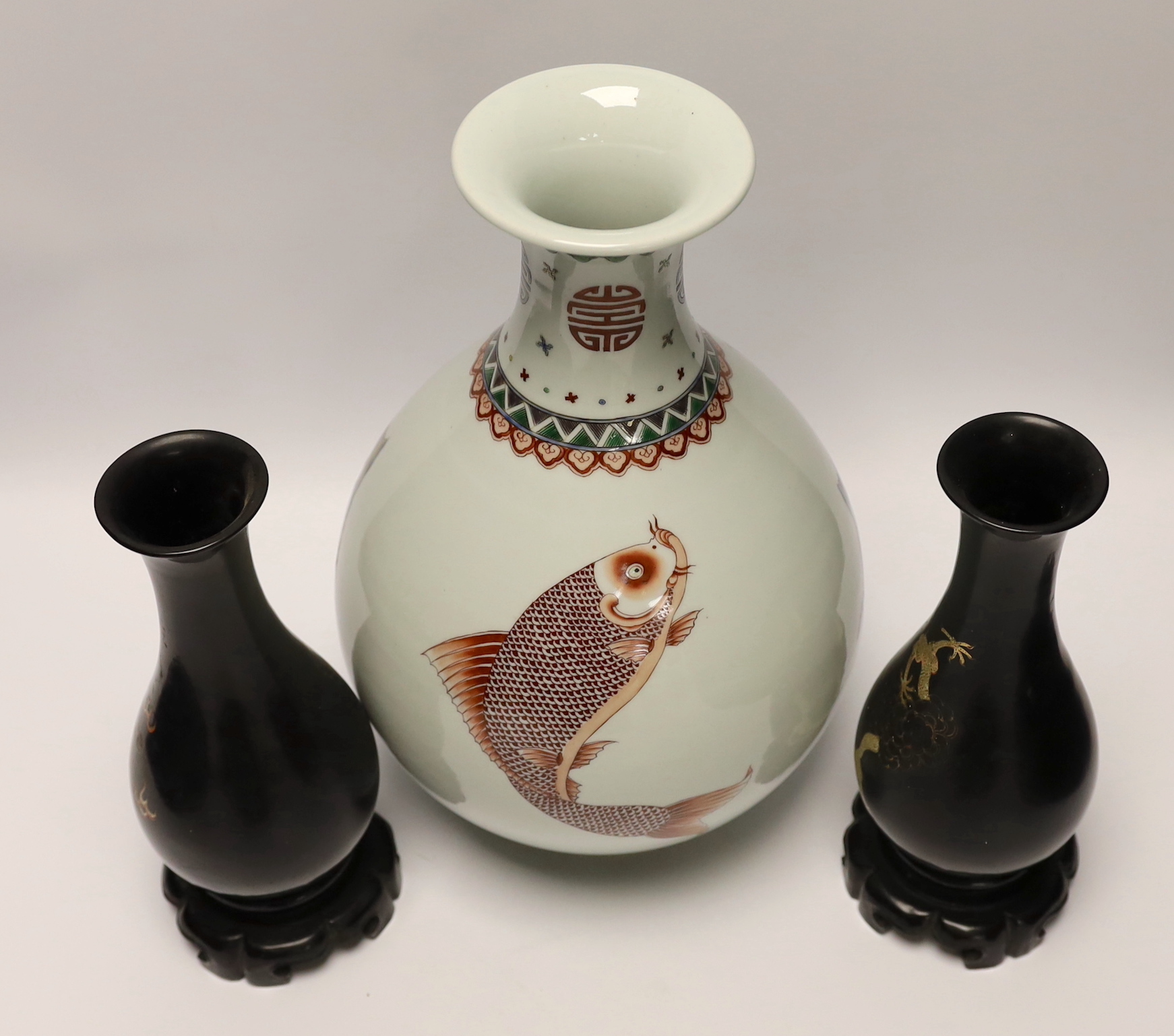 A Chinese porcelain ‘fish’ vase and a pair of Chinese lacquer vases on stands, tallest 33cm